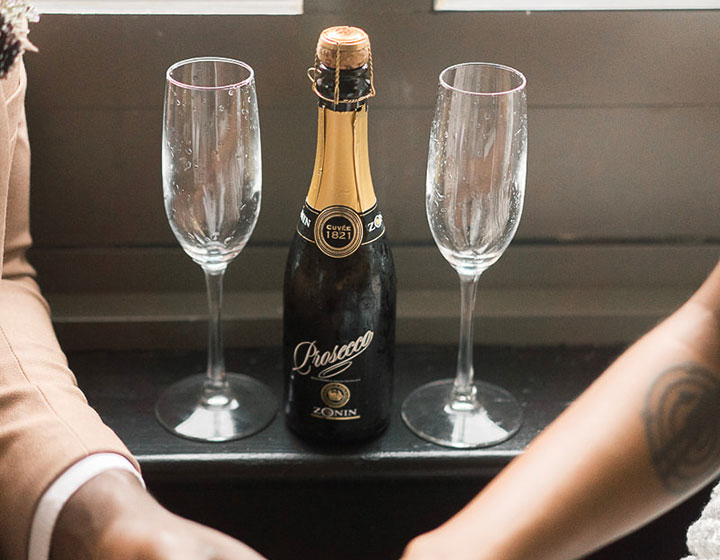 couple holding hands near champagne