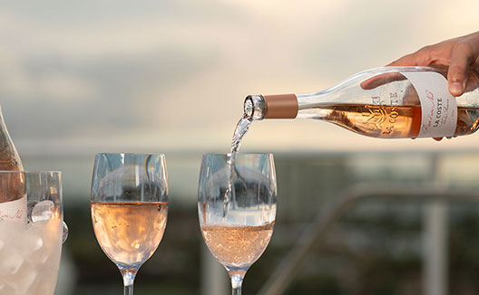 Wine being poured in front of sunset view